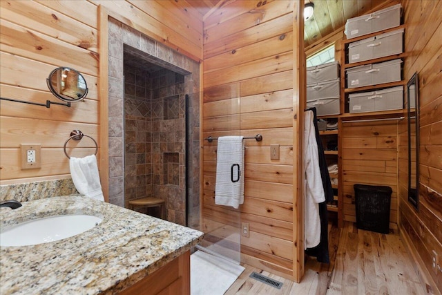 653 Natchez Ln, Sugar Grove, OH 43155 - bathroom with a shower stall, wood walls, vanity, and wood finished floors