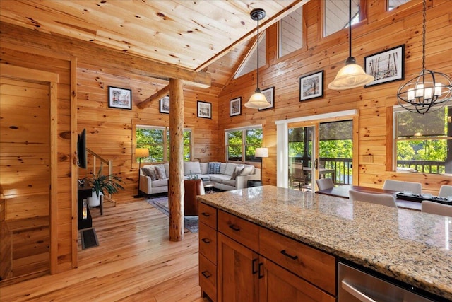 653 Natchez Ln, Sugar Grove, OH 43155 - kitchen featuring plenty of natural light, open floor plan, light wood-style flooring, wooden walls, and light stone counters