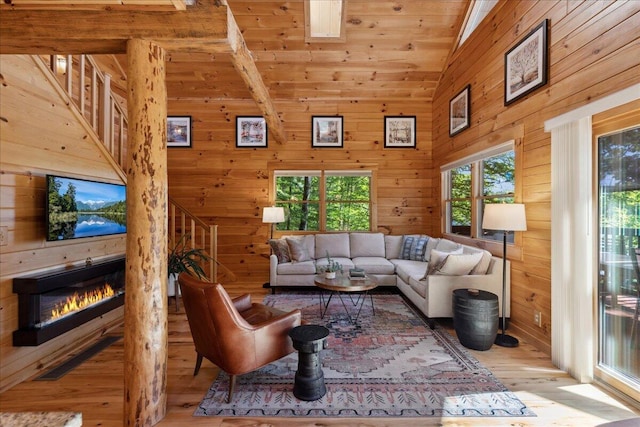 653 Natchez Ln, Sugar Grove, OH 43155 - living area featuring wood-type flooring, wooden walls, a glass covered fireplace, stairs, and lofted ceiling