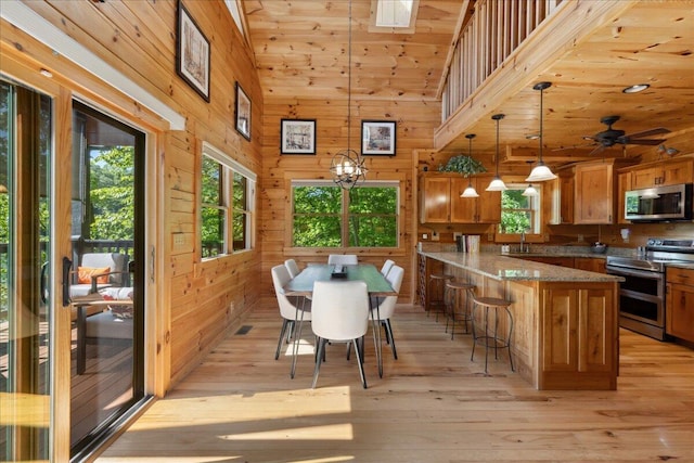 653 Natchez Ln, Sugar Grove, OH 43155 - dining area with light wood-type flooring, wooden walls, lofted ceiling, and a ceiling fan