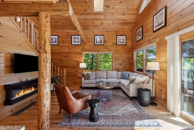 653 Natchez Ln, Sugar Grove, OH 43155 - living room with hardwood / wood-style floors, lofted ceiling, a glass covered fireplace, wooden walls, and stairway