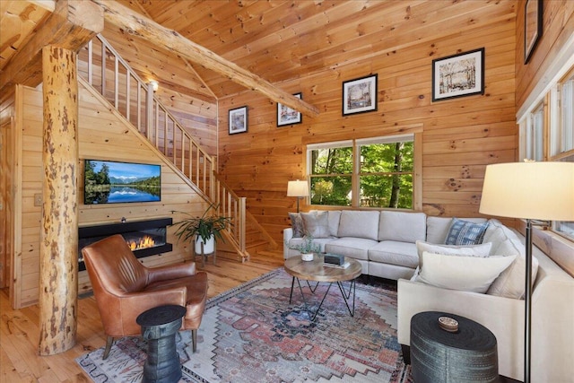 653 Natchez Ln, Sugar Grove, OH 43155 - living area featuring wood-type flooring, stairway, wood walls, wood ceiling, and a glass covered fireplace