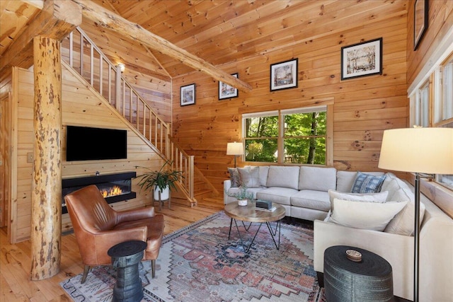 653 Natchez Ln, Sugar Grove, OH 43155 - living room featuring hardwood / wood-style flooring, stairs, wooden walls, wood ceiling, and a glass covered fireplace