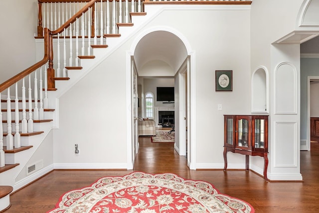 5360 Smothers Rd, Westerville, OH 43081 - entrance foyer featuring wood finished floors, stairway, a fireplace, baseboards, and arched walkways