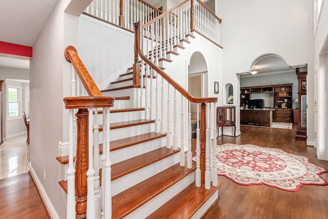 5360 Smothers Rd, Westerville, OH 43081 - stairs with arched walkways, wood finished floors, baseboards, and a towering ceiling