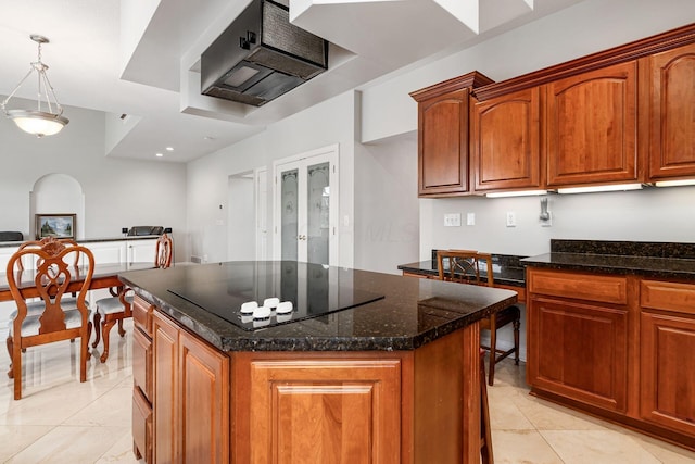 5360 Smothers Rd, Westerville, OH 43081 - kitchen featuring black electric stovetop, a center island, dark stone countertops, under cabinet range hood, and pendant lighting