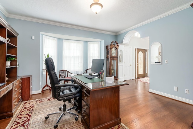 5360 Smothers Rd, Westerville, OH 43081 - home office with dark wood-style floors, crown molding, baseboards, a textured ceiling, and arched walkways