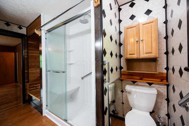 1959 Chapel Creek Rd, Chillicothe, OH 45601 - full bathroom featuring tile walls, wood finished floors, toilet, a shower stall, and a textured ceiling
