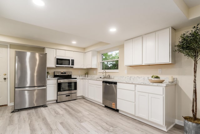 1419 Hentz Dr, Reynoldsburg, OH 43068 - kitchen with stainless steel appliances, a sink, light wood finished floors, white cabinets, and recessed lighting