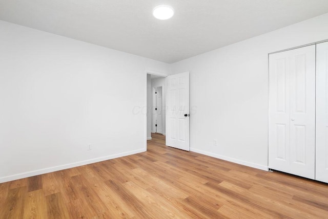 215 Stockbridge Rd, Columbus, OH 43207 - unfurnished bedroom with baseboards, light wood-style floors, and a closet