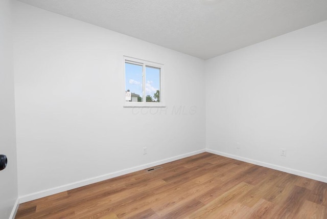 215 Stockbridge Rd, Columbus, OH 43207 - spare room with wood finished floors, baseboards, and a textured ceiling