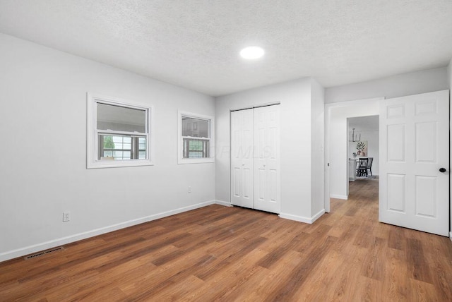 215 Stockbridge Rd, Columbus, OH 43207 - unfurnished bedroom featuring baseboards, wood finished floors, a textured ceiling, a closet, and recessed lighting