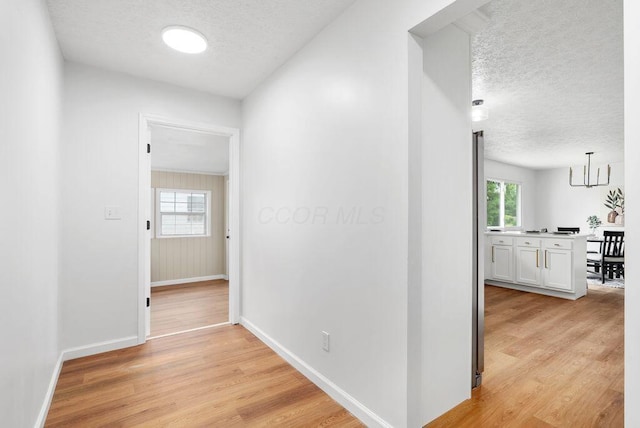 215 Stockbridge Rd, Columbus, OH 43207 - corridor with a textured ceiling, light wood-style flooring, healthy amount of natural light, and baseboards