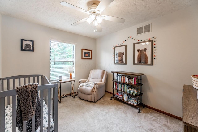 2643 Westrock Dr, Hilliard, OH 43026 - bedroom with light carpet, a nursery area, ceiling fan, a textured ceiling, and baseboards