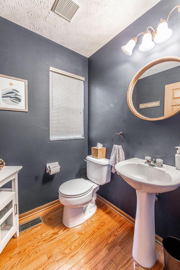 2643 Westrock Dr, Hilliard, OH 43026 - bathroom with wood finished floors, toilet, baseboards, a sink, and a textured ceiling