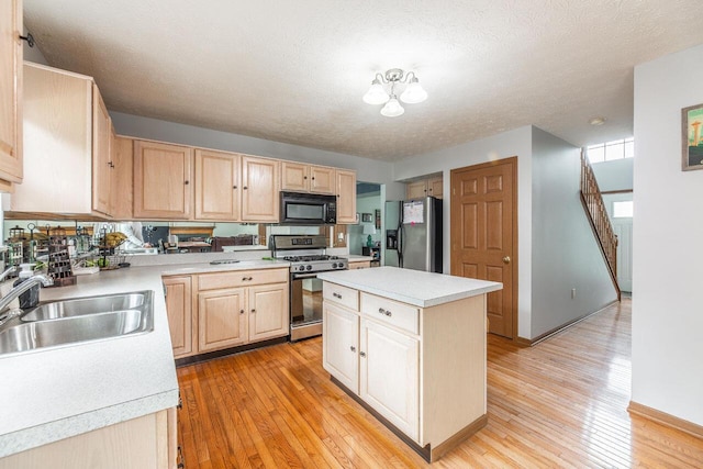 2643 Westrock Dr, Hilliard, OH 43026 - kitchen featuring appliances with stainless steel finishes, light brown cabinetry, a sink, light countertops, and a textured ceiling
