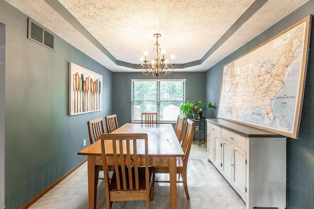 2643 Westrock Dr, Hilliard, OH 43026 - dining room with a chandelier, a textured ceiling, a raised ceiling, baseboards, and light carpet