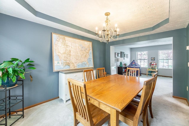 2643 Westrock Dr, Hilliard, OH 43026 - dining space with light carpet, a chandelier, baseboards, a textured ceiling, and a raised ceiling