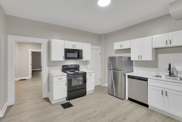 358 Saint Clair Ave, Columbus, OH 43203 - kitchen featuring black appliances, a sink, light wood-style floors, and white cabinetry