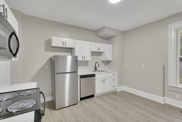 358 Saint Clair Ave, Columbus, OH 43203 - kitchen featuring black appliances, a sink, baseboards, and light wood-style flooring
