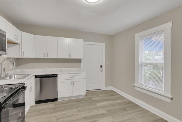 358 Saint Clair Ave, Columbus, OH 43203 - kitchen with appliances with stainless steel finishes, a sink, light countertops, white cabinetry, and light wood-style flooring