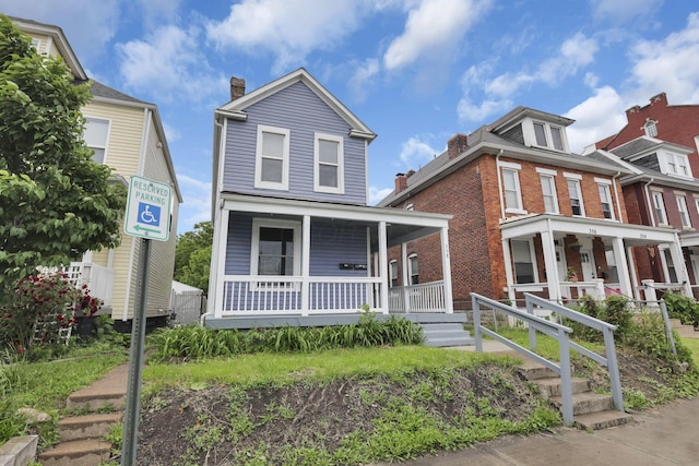 358 Saint Clair Ave, Columbus, OH 43203 - view of front facade featuring covered porch, a chimney, and brick siding