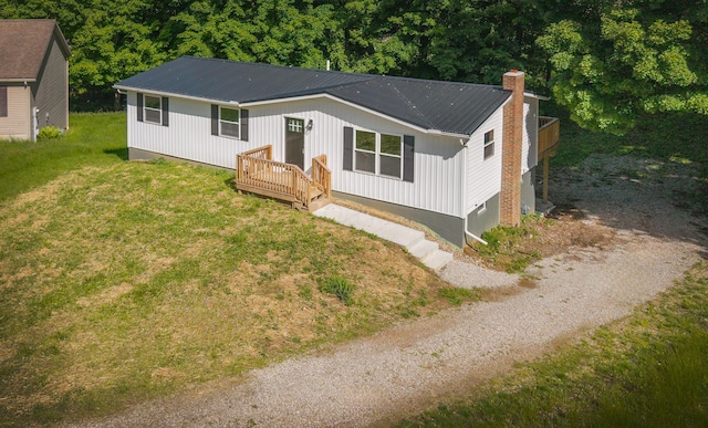 26 Crabtree Ct, Howard, OH 43028 - view of front of property with metal roof, a chimney, a front lawn, gravel driveway, and a wooden deck