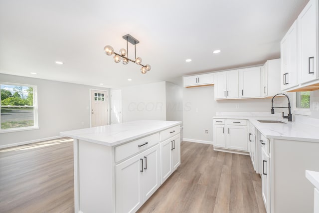 26 Crabtree Ct, Howard, OH 43028 - kitchen featuring a sink, light wood-style flooring, light stone counters, baseboards, and recessed lighting