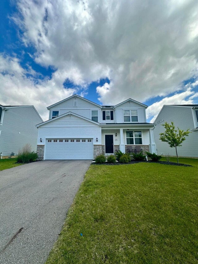 257 Whitetail Trl, Johnstown, OH 43031 - view of front of property with stone siding, asphalt driveway, an attached garage, and a front yard