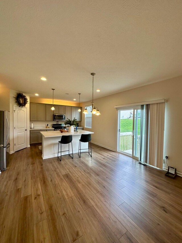 257 Whitetail Trl, Johnstown, OH 43031 - kitchen with stainless steel appliances, light countertops, dark wood-style floors, a kitchen bar, and recessed lighting