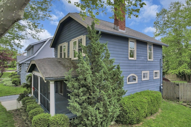 249 Blenheim Rd, Columbus, OH 43214 - view of side of home with a chimney, a sunroom, and roof with shingles