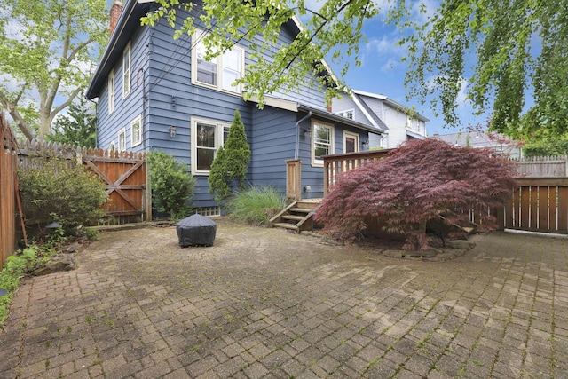 249 Blenheim Rd, Columbus, OH 43214 - back of property featuring a deck, a patio, a fenced backyard, and a chimney