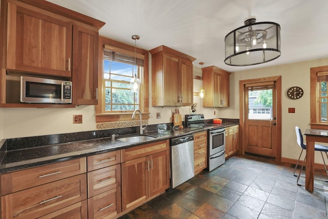 249 Blenheim Rd, Columbus, OH 43214 - kitchen with stainless steel appliances, a sink, stone tile floors, and brown cabinets