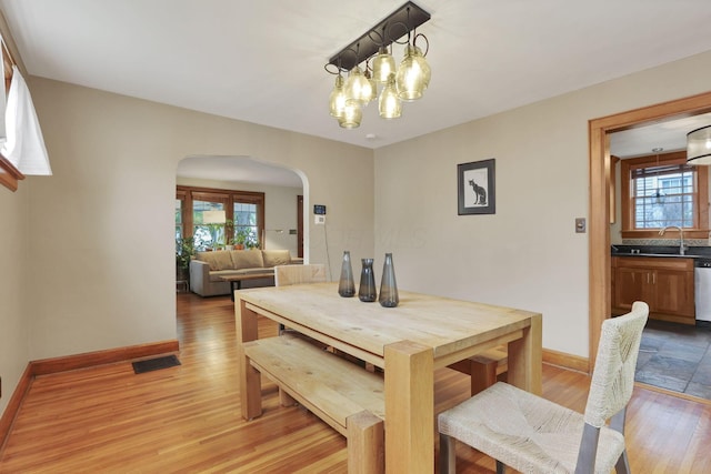 249 Blenheim Rd, Columbus, OH 43214 - dining space featuring arched walkways, plenty of natural light, light wood finished floors, and baseboards