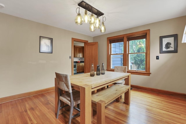 249 Blenheim Rd, Columbus, OH 43214 - dining room with baseboards, light wood-style floors, and a chandelier