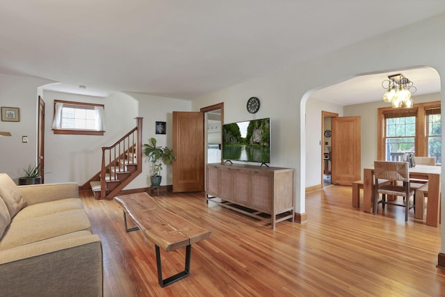 249 Blenheim Rd, Columbus, OH 43214 - living room featuring arched walkways, light wood-style flooring, baseboards, and a chandelier