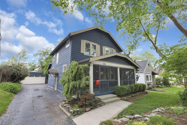 249 Blenheim Rd, Columbus, OH 43214 - view of front of house featuring a sunroom, a garage, an outdoor structure, and a front lawn