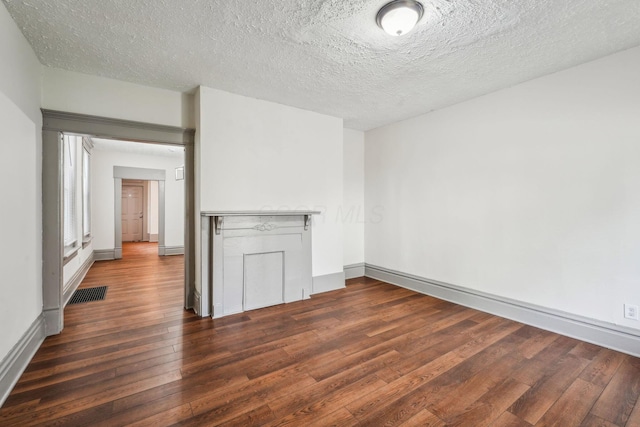 112 S Cypress Ave, Columbus, OH 43222 - unfurnished living room featuring dark wood-style floors, baseboards, a textured ceiling, and a baseboard heating unit