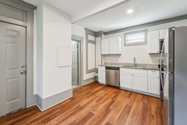 112 S Cypress Ave, Columbus, OH 43222 - kitchen featuring stainless steel appliances, a sink, white cabinetry, light stone countertops, and light wood-style flooring