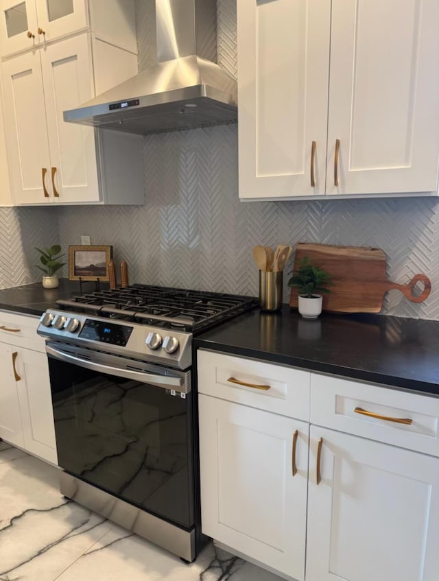 1217 Franklin Ave, Columbus, OH 43205 - kitchen with stainless steel gas stove, ventilation hood, white cabinetry, and tasteful backsplash