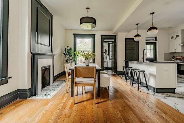 1217 Franklin Ave, Columbus, OH 43205 - dining space featuring plenty of natural light, a fireplace with flush hearth, light wood finished floors, and baseboards