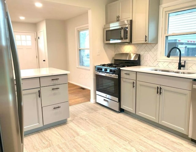 3434 Kenlawn St, Columbus, OH 43224 - kitchen with appliances with stainless steel finishes, a sink, gray cabinets, backsplash, and light countertops
