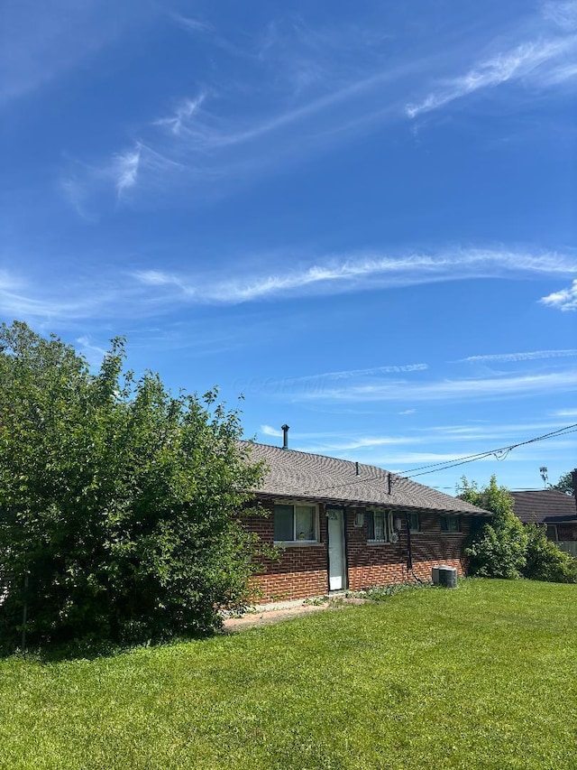 909 Stephen Dr W, Columbus, OH 43204 - rear view of property with brick siding, a lawn, and central AC