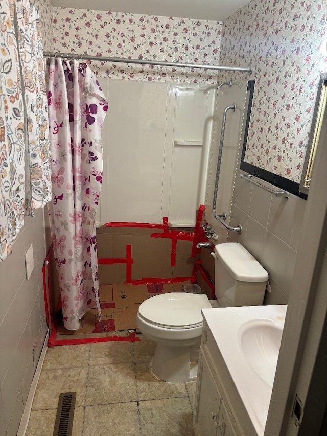 909 Stephen Dr W, Columbus, OH 43204 - full bath featuring wallpapered walls, a shower with curtain, tile walls, toilet, and vanity