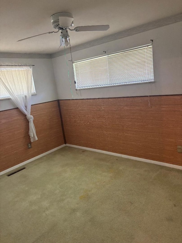 909 Stephen Dr W, Columbus, OH 43204 - empty room featuring carpet, ceiling fan, healthy amount of natural light, and wainscoting