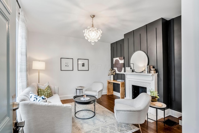 976 Oakwood Ave, Columbus, OH 43206 - living room with a chandelier, baseboards, dark wood-style flooring, and a fireplace