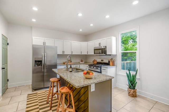 976 Oakwood Ave, Columbus, OH 43206 - kitchen with appliances with stainless steel finishes, a sink, light tile patterned floors, recessed lighting, and decorative backsplash