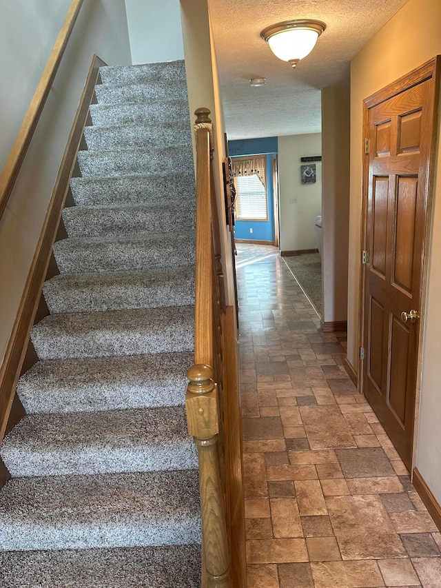 350 S Houston Pike, South Vienna, OH 45369 - stairs with baseboards, a textured ceiling, and stone finish floors