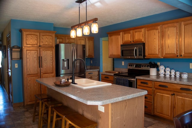 350 S Houston Pike, South Vienna, OH 45369 - kitchen featuring appliances with stainless steel finishes, a sink, stone finish floors, brown cabinetry, and a textured ceiling