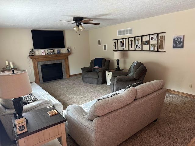 350 S Houston Pike, South Vienna, OH 45369 - carpeted living area featuring a ceiling fan, a tiled fireplace, a textured ceiling, and baseboards